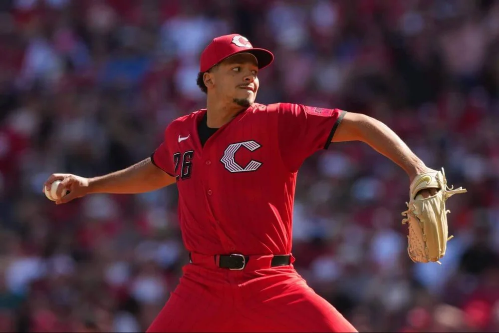 Chase Burns, in the Reds' all-red City Connect uniform, winds back to pitch.