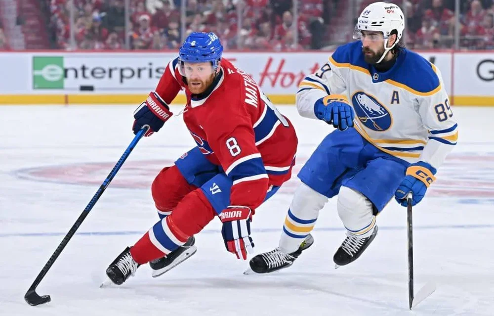 Mike Matheson #8 of the Montreal Canadiens skates with the puck against Alex Tuch #89 of the Buffalo Sabres.